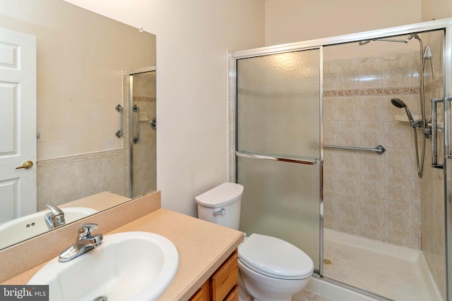 bathroom with vanity, toilet, and a shower with shower door