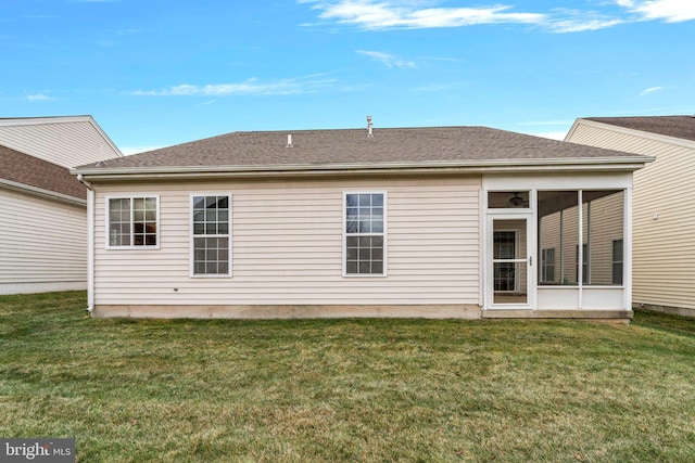 back of property with a sunroom and a yard