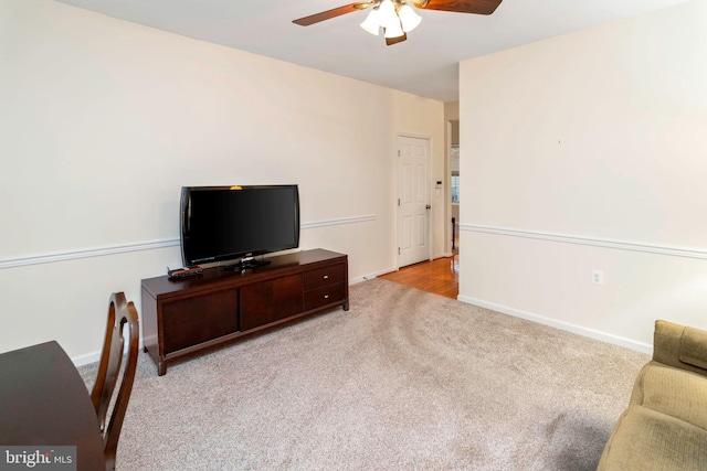 carpeted living room with ceiling fan