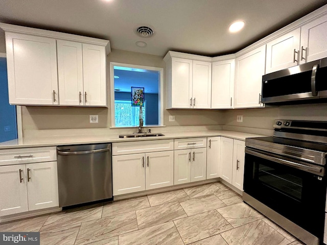 kitchen with white cabinets, appliances with stainless steel finishes, and sink