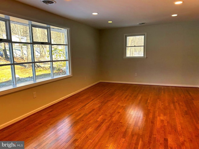 spare room with plenty of natural light and hardwood / wood-style flooring