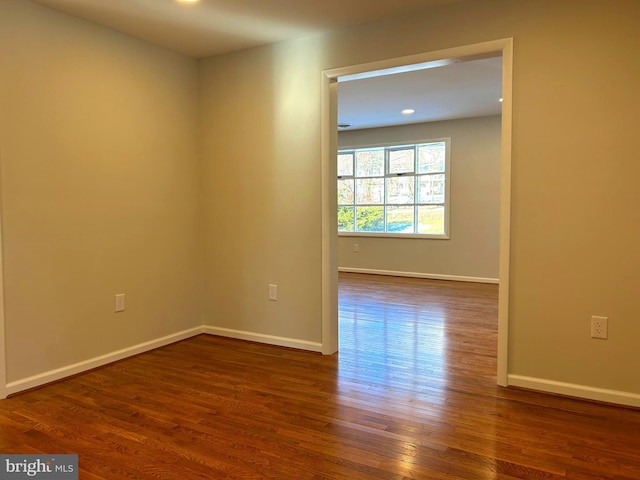 unfurnished room with dark hardwood / wood-style flooring