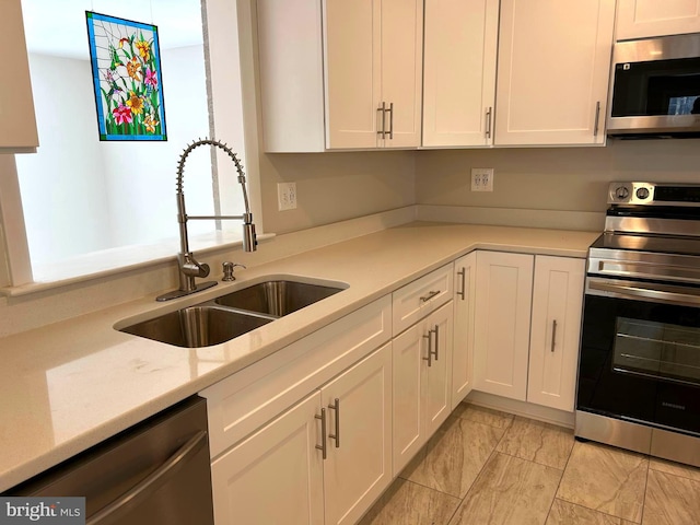 kitchen with sink, white cabinets, and appliances with stainless steel finishes