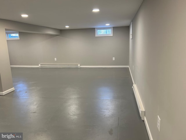 basement featuring baseboard heating and a wealth of natural light