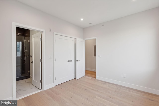 unfurnished bedroom with a closet and light hardwood / wood-style flooring