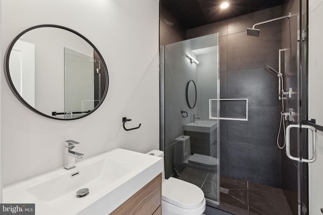 bathroom with vanity, an enclosed shower, and toilet