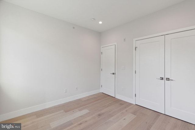 unfurnished bedroom featuring light hardwood / wood-style flooring and a closet