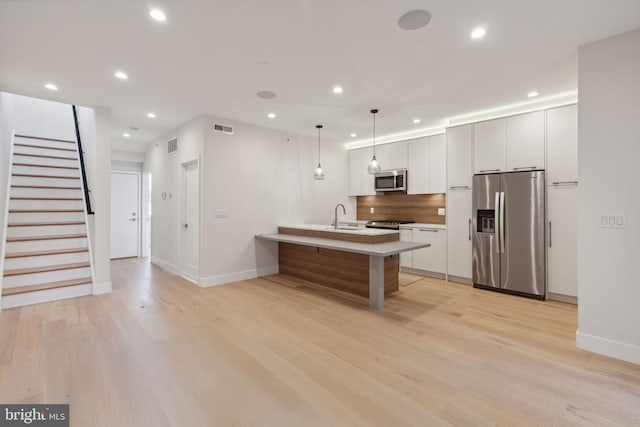 1610 Germantown Ave Unit C, Philadelphia, PA 19122 - kitchen featuring appliances with stainless steel finishes, recessed lighting, a peninsula, light wood-style flooring, and light countertops