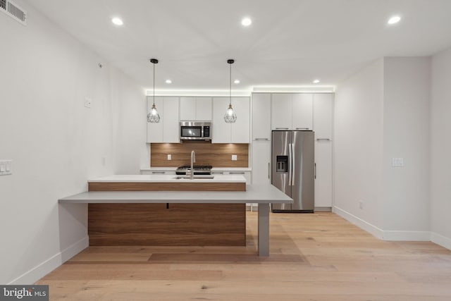 1610 Germantown Ave Unit C, Philadelphia, PA 19122 - kitchen featuring appliances with stainless steel finishes, light countertops, recessed lighting, light wood finished floors, and a peninsula