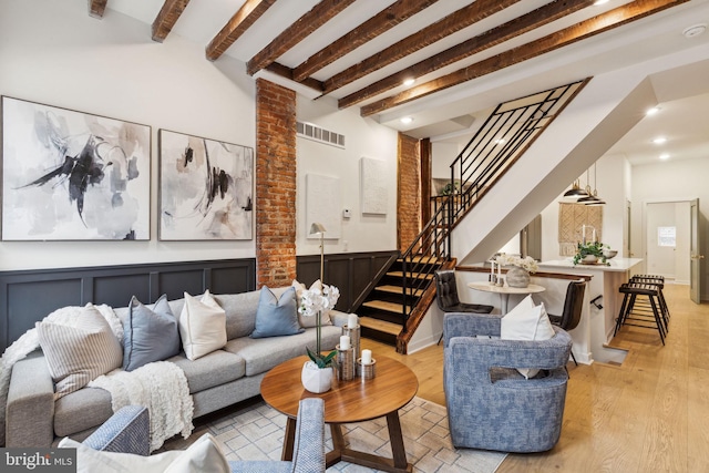 living room with beam ceiling and light wood-type flooring