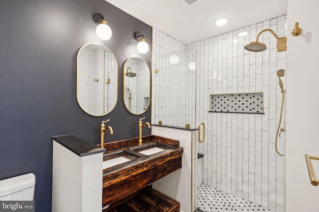 bathroom featuring sink, a shower with shower door, and toilet