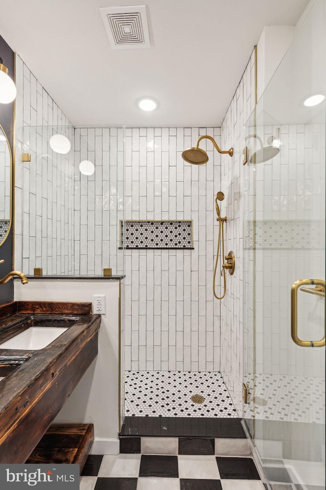 bathroom with a shower with door and sink