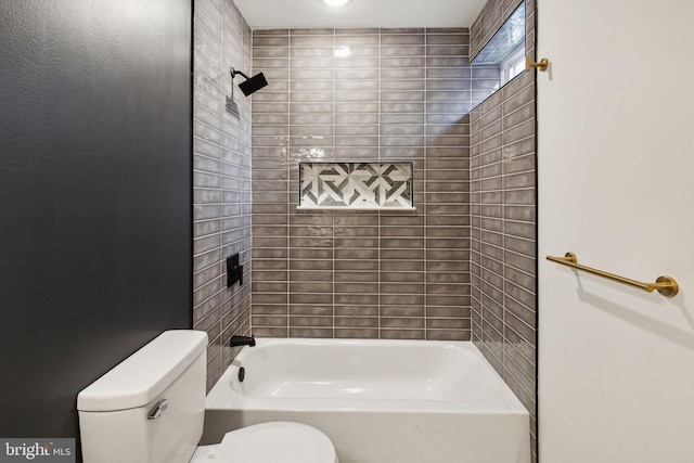 bathroom featuring toilet and tiled shower / bath