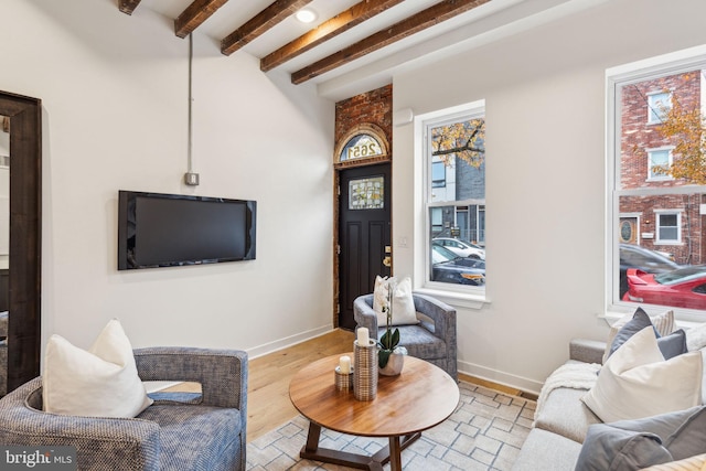 living room with beamed ceiling and light hardwood / wood-style flooring