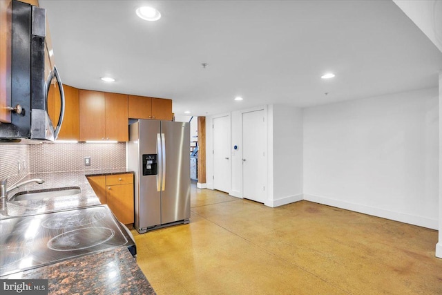 kitchen featuring sink, range, stainless steel refrigerator with ice dispenser, and tasteful backsplash