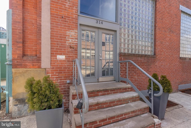 doorway to property featuring french doors and brick siding