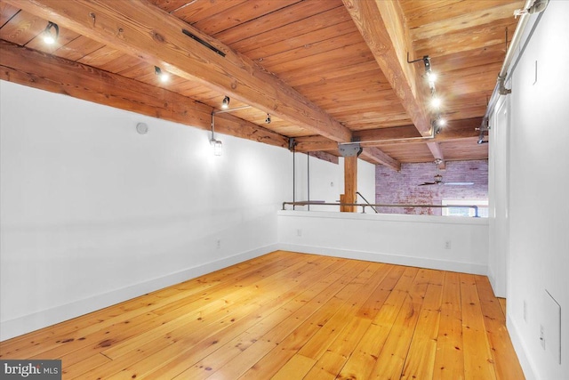 spare room with beamed ceiling, wood ceiling, and light wood-type flooring