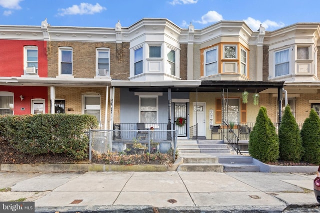 townhome / multi-family property featuring cooling unit and covered porch