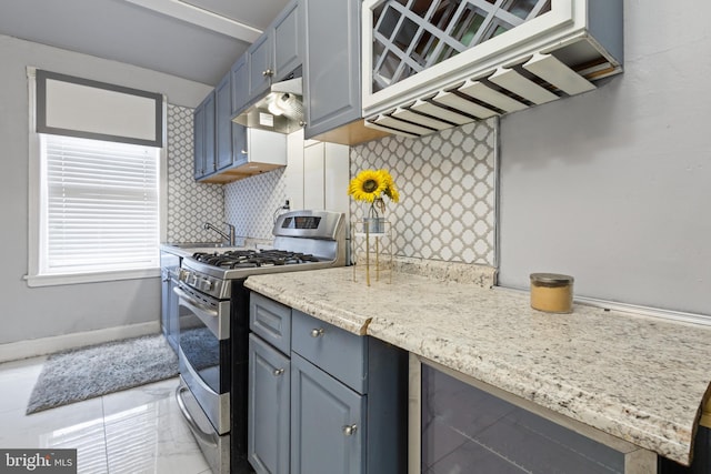 kitchen featuring decorative backsplash, gas stove, light tile patterned flooring, and sink