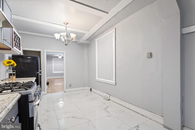 kitchen with light stone countertops, an inviting chandelier, and stainless steel range with gas cooktop