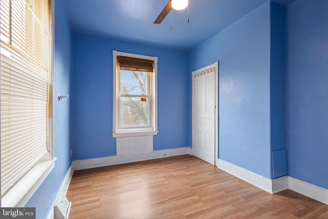 empty room with ceiling fan and light hardwood / wood-style floors