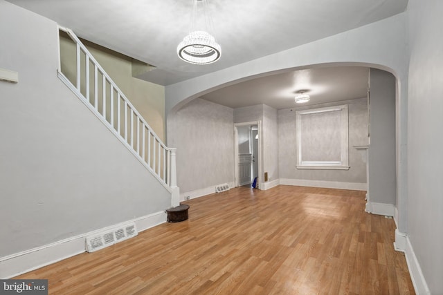 interior space with a notable chandelier and wood-type flooring