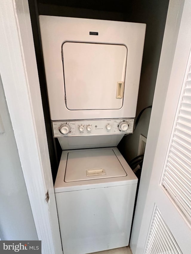 laundry room with stacked washer / dryer