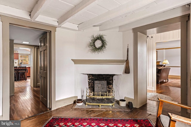 living room featuring beamed ceiling and dark hardwood / wood-style floors