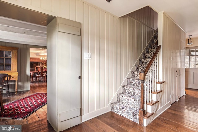 stairs featuring wood-type flooring and wooden walls