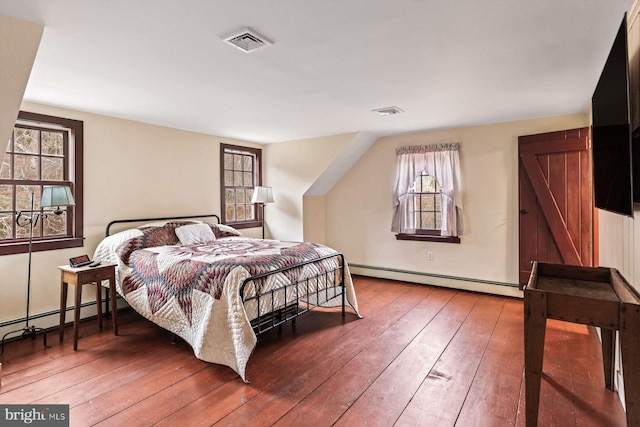 bedroom with hardwood / wood-style flooring and a baseboard radiator