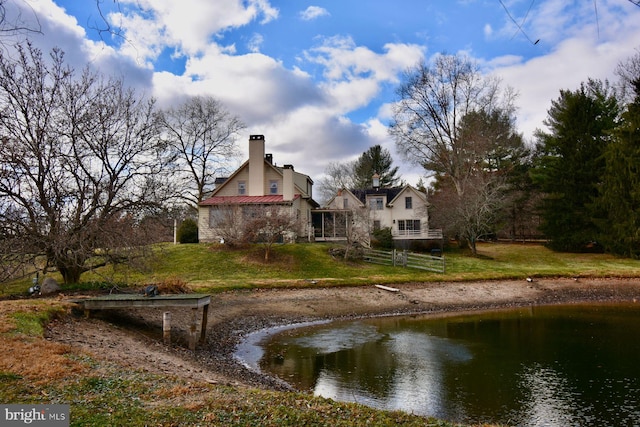 exterior space featuring a lawn and a water view