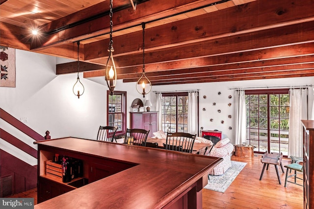 dining room with beam ceiling, light wood-type flooring, and wooden ceiling