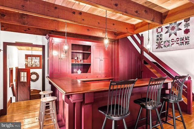 bar with beam ceiling, wood ceiling, hanging light fixtures, and light hardwood / wood-style floors