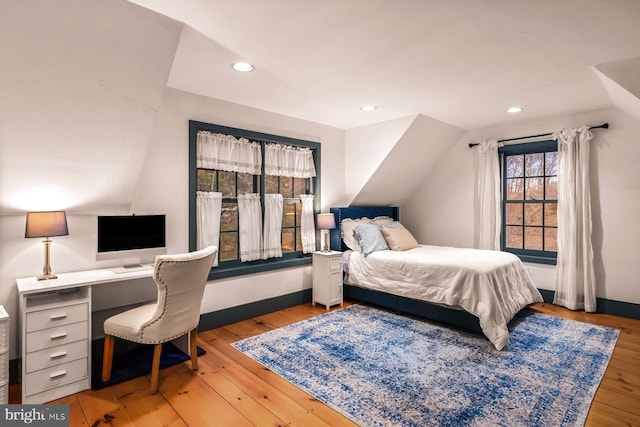 bedroom featuring light hardwood / wood-style floors and lofted ceiling