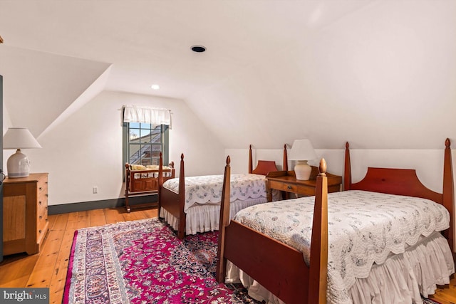 bedroom featuring vaulted ceiling and light hardwood / wood-style flooring