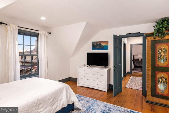 bedroom with lofted ceiling and light hardwood / wood-style flooring