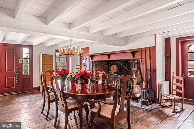 dining room with beam ceiling, radiator, dark wood-type flooring, an inviting chandelier, and wood ceiling