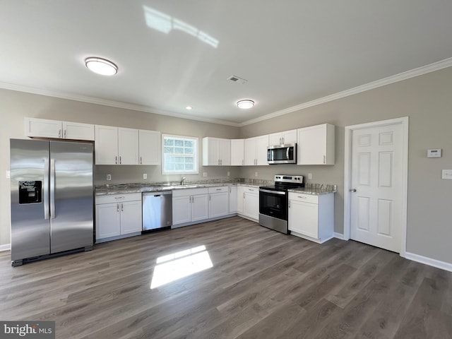 kitchen with dark hardwood / wood-style flooring, white cabinetry, stainless steel appliances, and ornamental molding