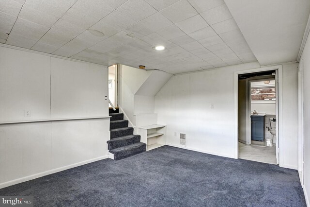 basement featuring sink and light colored carpet