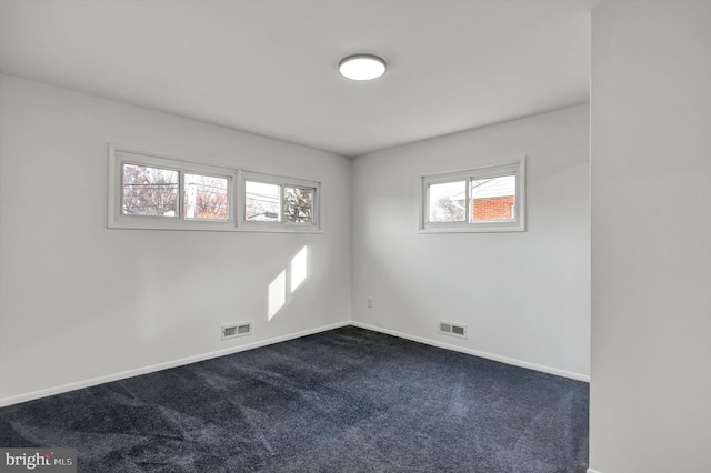 unfurnished room with dark colored carpet