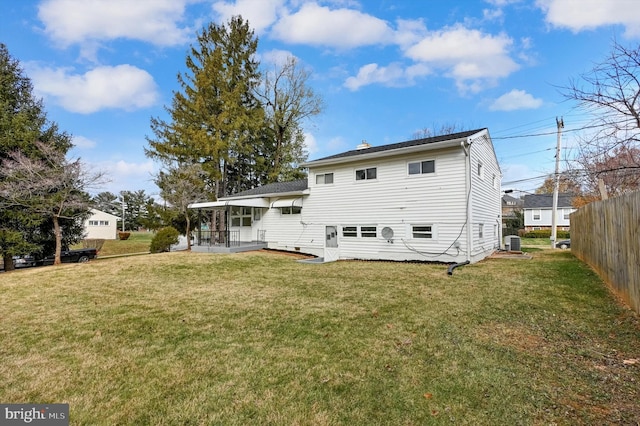 back of house featuring a yard and central AC