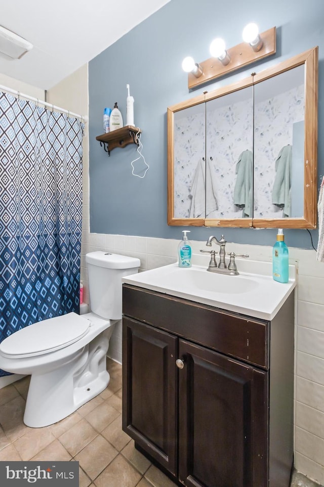 bathroom with tile patterned floors, vanity, tile walls, and toilet