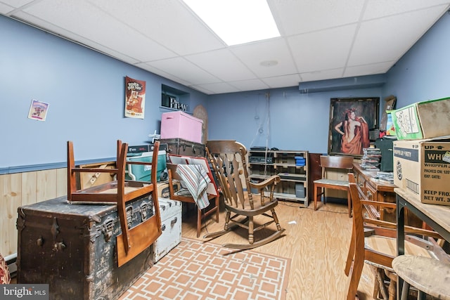 bedroom featuring hardwood / wood-style floors, a paneled ceiling, and wood walls