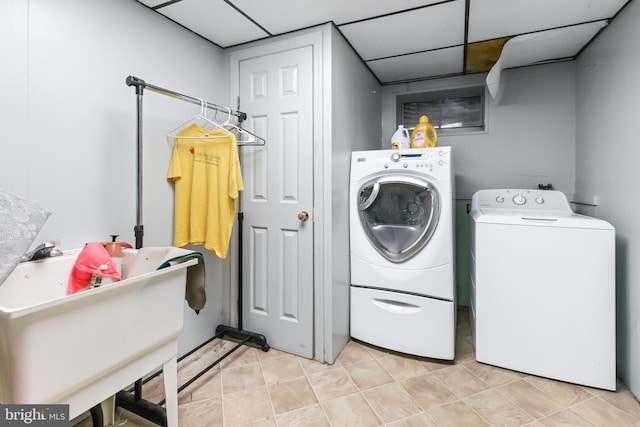 laundry room featuring sink, light tile patterned floors, and independent washer and dryer