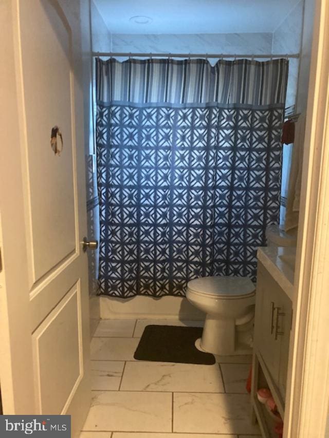 bathroom featuring a shower with curtain and toilet