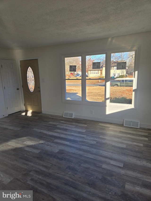 entrance foyer with dark hardwood / wood-style floors and a textured ceiling