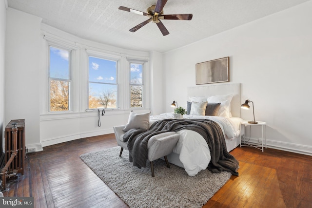 bedroom with a textured ceiling, dark hardwood / wood-style flooring, and ceiling fan