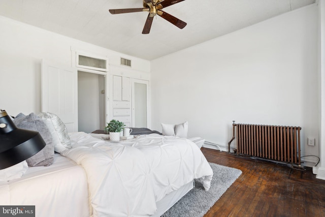 bedroom featuring ceiling fan, dark hardwood / wood-style floors, and radiator