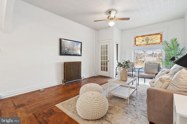 living room featuring ceiling fan, radiator heating unit, and parquet floors