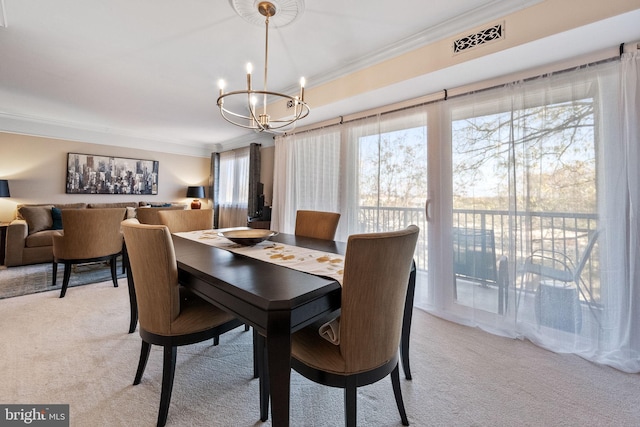 dining area featuring a chandelier, light colored carpet, and ornamental molding